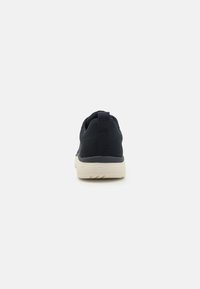 Sötétkék hálós sneaker textúrált felülettel, fehér gumitalppal, megerősített hátsó pánttal és alacsony profilú kialakítással.