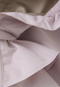 Lyslilla stof med et tekstureret skr�å mønster, som har en samlet elastisk kant og en glat beige foring.