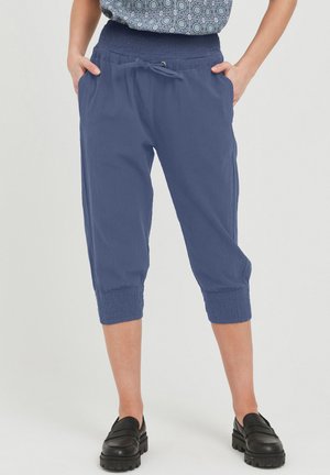 Pantaloni blu a vita alta, con elastico e cordino regolabile. Tasche anteriori e polsini arricciati, realizzati in tessuto leggero e testurizzato.