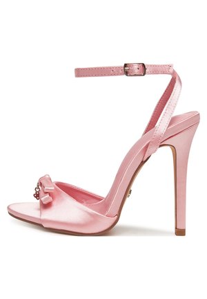 Różowy satynowy sandał na wysokim obcasie z paskiem wokół kostki, odkrytymi palcami i ozdobną kokardą na przednim pasku, widok z boku.