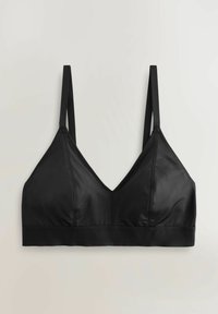 Crna braletica od mekane, glatke tkanine. Ima tanke podesive naramenice, dubok V-izrez i rastezljivi donji pojas za potporu.