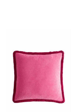 Coussin carré en velours rose avec bordure à franges rouge foncé sur fond blanc.