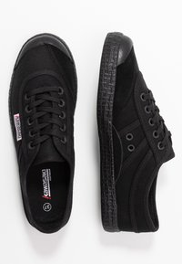 Baskets noires avec tige en toile et accents en daim, capuchon en caoutchouc à l'avant, semelle texturée noire et six œillets pour les lacets. Taille 37.