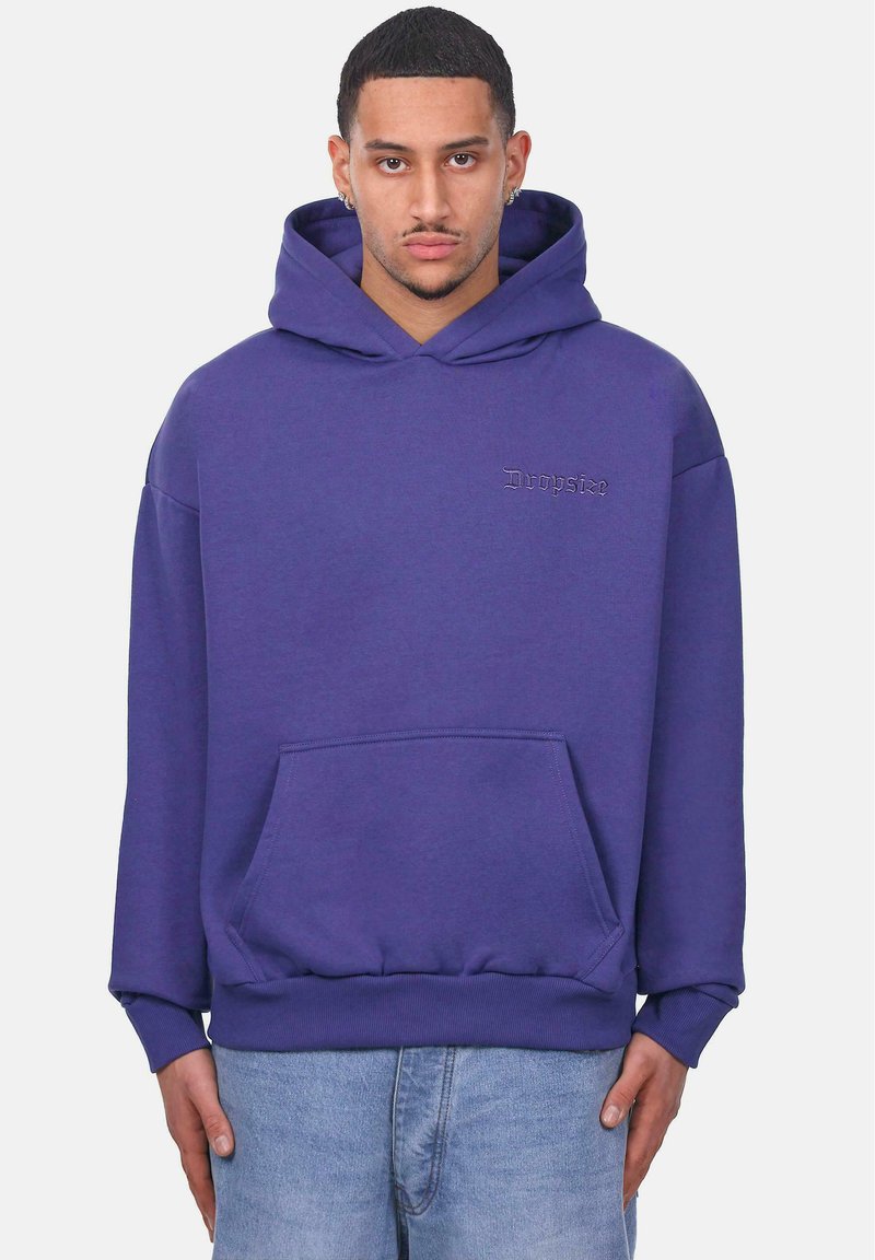 Purple pullover hoodie with a front pocket, drawstring hood, ribbed cuffs, and hem. Features logo text in a lighter shade on the chest.