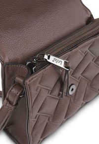 Bolso cruzado de cuero marrón con textura trenzada, bolsillo exterior con cremallera y herrajes en color plateado, y correa ajustable.