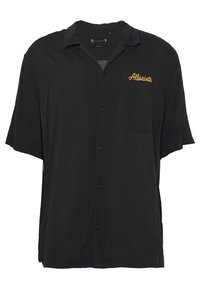 Svart kortärmad skjorta i mjukt tyg, med knapplist fram, en ficka och "AllSaints" broderat i guld.