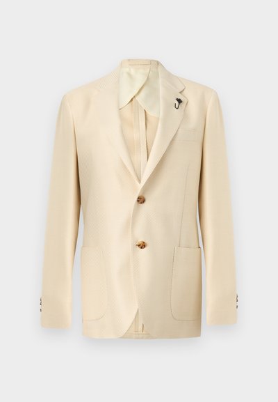 Μπεζ σακάκι ανδρικό σε κρεμ απόχρωση με δύο καφέ κουμπιά, γιακά με εγκοπή, τσέπη στο στήθος και δύο τσέπες με καπάκι εμπρός σε μονόχρωμο φόντο.