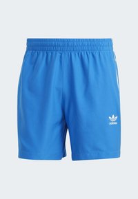 Pantaloni sportivi blu realizzati in tessuto sintetico liscio. Presentano una cintura elastica e un logo Adidas bianco sulla parte anteriore inferiore.