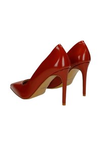 Czerwone lakierowane szpilki z ostrym noskiem i wycięciem z przodu. Charakteryzują się wysokim obcasem typu szpilka i gładką fakturą.