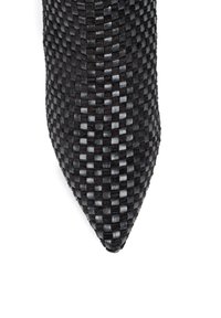 Wykonana z czarno-szarej dzianiny cholewka z ostrym noskiem. Tekstura jest gładka z wzorem w szachownicę. Odpowiednia na formalne okazje.