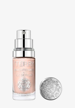 Sérum éclaircissant By Terry Brightening CC dans un flacon en verre givré avec pompe argentée et capuchon décoratif argenté, arborant un logo de rose et du texte.