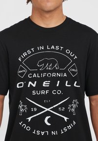 Sort bomulds t-shirt med hvid grafisk tekst og designs, herunder en bjørn, krydsede surfbrætter og palmer. Casual pasform.