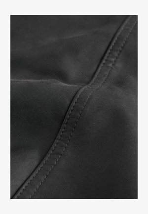 Melnas ādas materiāls ar gludu tekstūru un redzamām šuvju detaļām. Tam ir plakana, salocīta forma ar maigu spīdumu.