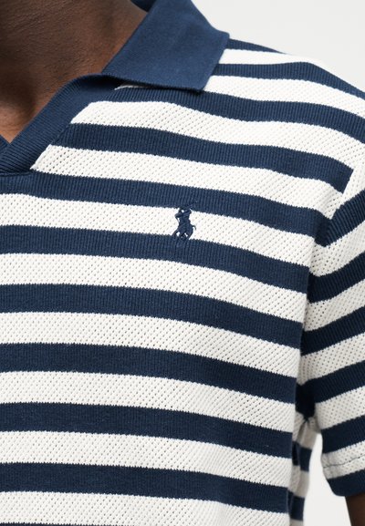 Polo de punto con rayas azul marino y blancas, con mangas cortas, cuello azul marino y pequeño logo de caballo bordado en azul marino en el pecho.