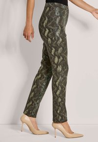 Groene en zwarte slangenleren broeken met een slim fit, voorzien van een gladde textuur en hoge tailleband, gecombineerd met naakte hoge hakken.