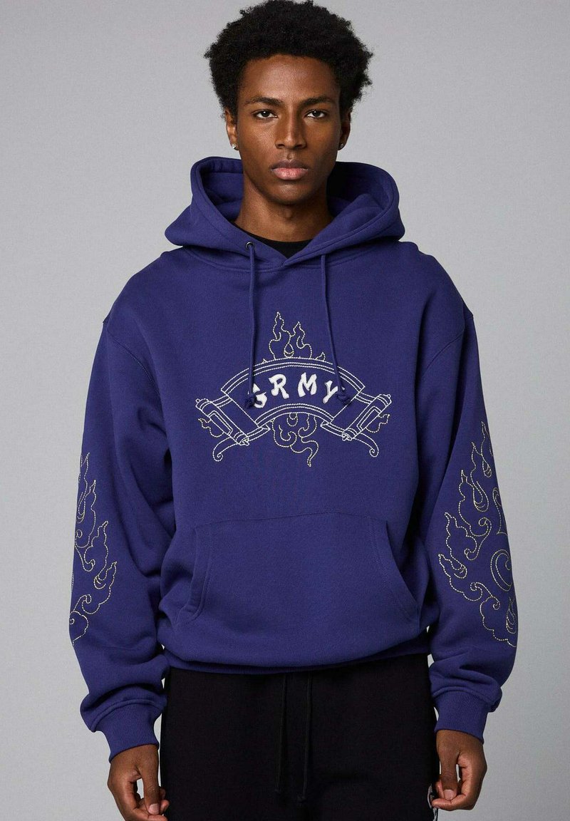 Marine hoodie met witte "ARMY" tekst en decoratieve vlamachtige borduursels op de mouwen. Zacht materiaal, oversized ontwerp, kangoeroezak.