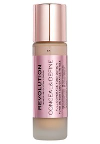 Fond de teint liquide dans une bouteille transparente avec une base givrée. Présente une pompe réfléchissante en or rose et une étiquette, portant la mention "Conceal & Define."