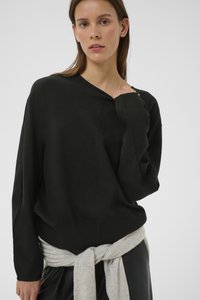 Mustast kangast v-kaelusega kampsun, lahtise lõike ja pikkade varrukatega. Helehall kampsun on vöökohast seotud, lisades tekstuuri ja kontrasti.