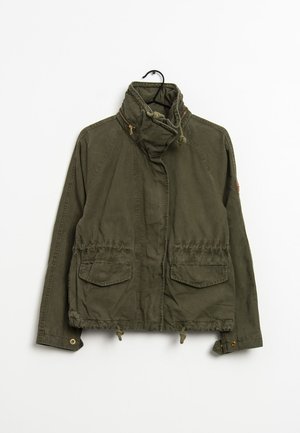 Olivgrüne, leichte Jacke mit hohem Kragen, zwei Vordertaschen und Zugbanddetails am Saum und an den Manschetten. Mit Reißverschluss.