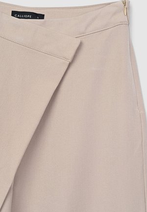 Beige asymmetrical skirt with overlapping front panel, side zipper, and visible black brand label "CALLIOPE" in size small.