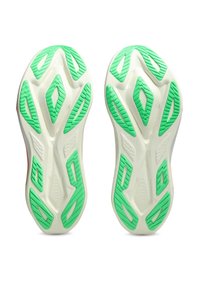 Εξωτερική σόλα λευκών αθλητικών παπουτσιών με πράσινα λαστιχένια σχέδια πρόσφυσης, τοποθετημένα δίπλα δίπλα, θέα από κάτω.