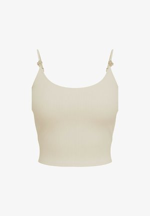 Top corto a coste beige con sottili spalline regolabili e piccole decorazioni floreali vicino agli attacchi delle spalline.