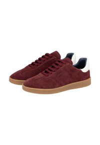 Baskets en cuir suédé bordeaux avec six œillets noirs, semelle en caoutchouc beige, languette blanche au talon et détails perforés sur les côtés.