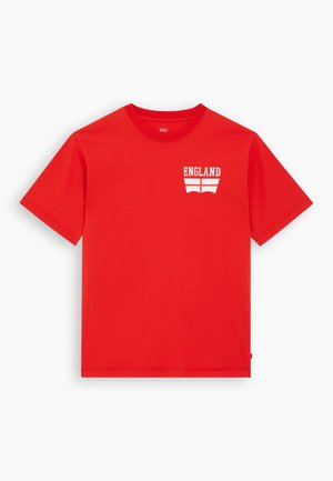 Red cotton t-shirt featuring a white graphic saying "ENGLAND" above a stylized flag design on the left chest area. Short sleeves, standard fit.