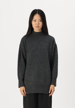 Maglione oversize grigio scuro con collo alto. Materiale a maglia testurizzato, spalle basse e polsini e orlo a coste per un tocco di dettaglio.