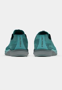 Tyrkist mesh-löparskor med svarta detaljer, vadderad krage och en grå sula med strukturerat mönster för bättre grepp.