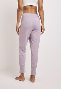 Lilac joggers gemaakt van zacht, rekbaar materiaal. Ze hebben een brede tailleband en een elastische enkel, met een gladde textuur en een casual pasvorm.