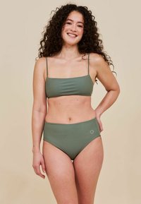 Due pezzi bikini in verde oliva. Il top presenta spalline sottili e una forma rettangolare, mentre il fondo a vita alta ha una texture liscia.