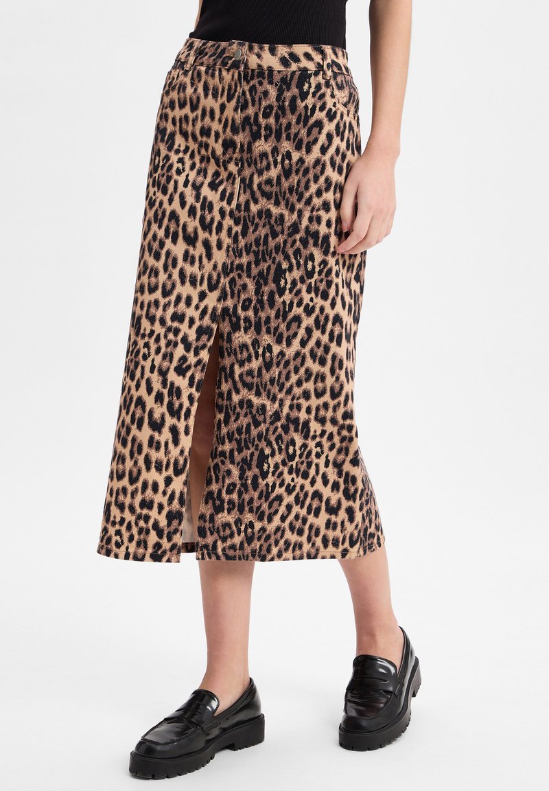 Leopardenmuster-Midirock in Beige und Schwarz mit einem seitlichen Schlitz. Hat eine enganliegende Taille und eine glatte Textur, kombiniert mit schwarzen Loafers.