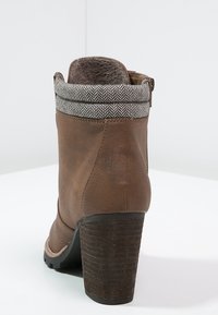 Brązowe skórzane botki za kostkę z teksturowanym szarym mankietem, słupkowym obcasem i zamkiem błyskawicznym z boku. Posiadają gumową podeszwę zapewniającą przyczepność.