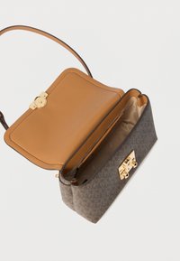 Borsa con esterno scuro a motivo e interno in pelle liscia color cuoio chiaro. Presenta una chiusura dorata e una sottile tracolla.