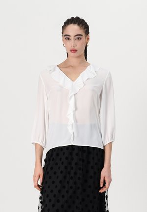 Weiße Bluse aus leichtem Stoff mit V-Ausschnitt und Rüschendetail an der Vorderseite; 3/4-Ärmel mit gerafften Manschetten.