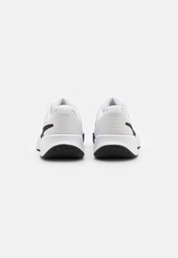Białe sneakersy z teksturowanym wierzchem, czarnymi akcentami i grubą gumową podeszwą. Zaprojektowane z myślą o komforcie i stabilności. Bez widocznych logo.