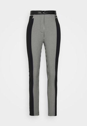 Tailored pants featuring a black and white gingham pattern, black side panels, and a sleek waistband with a button closure.