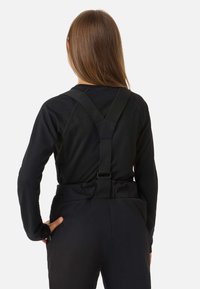 Musta pitkähiha-paita ribbineuloksella ja mustat henkselit. Takana on sileä vyötärönauha ja housuissa sivutaskut.