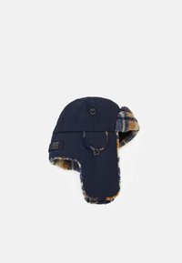 Marineblauwe wintermuts met oorflappen, voorzien van een zachte geruite voering in tinten bruin en blauw, en twee zwarte knopen om te bevestigen.