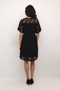 Black lace dress with short sleeves, lined bodice, and scalloped hem. Features a modest back neckline and a cinched waist for a fitted silhouette.