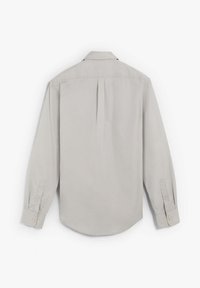 Camisa de manga larga gris claro con cuello abotonado, pliegue en la parte posterior, puños cosidos y dobladillo redondeado. Textura de tela suave.