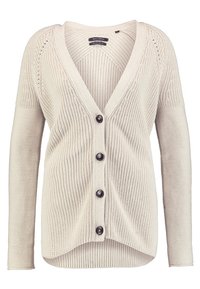 Světlý béžový kardigan s výstřihem do V, žebrovanou texturou a dlouhými rukávy. Má pět velkých černých knoflíků na přední straně a volný střih.