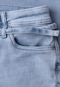 Jeans in denim azzurro chiaro con tasca frontale, passante per cintura e una stretta cintura in denim infilata nei passanti.