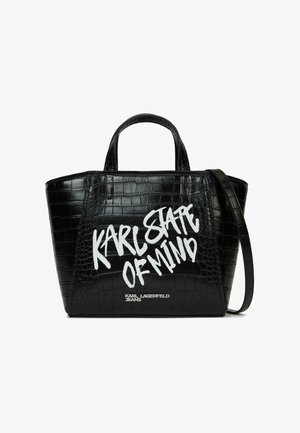 Sac à main en cuir synthétique noir effet crocodile, avec poignées supérieures et bandoulière, présentant un texte graffiti blanc « KARL STATE OF MIND » et un petit logo en dessous.