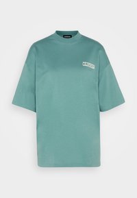 Mint green oversized t-shirt with a round neckline and short sleeves. Features a white "California" logo on the front. Soft cotton material.