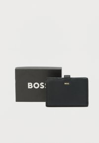 Čierna kožená peňaženka s hladkou textúrou a zlatým logom "BOSS", zobrazená vedľa čiernej kartónovej krabičky s nápisom "BOSS".
