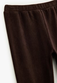 Braune Corduroy-Leggings mit weicher Textur, elastischem Bund und nahtlosen Seiten für ein elegantes Design.