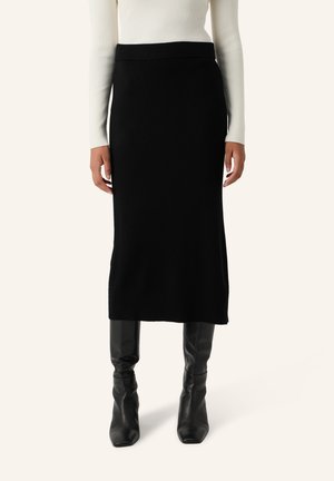 Zwarte gebreide midi rok met een aansluitende tailleband, een gladde textuur en een rechte silhouet, gecombineerd met strakke zwarte kniehoge laarzen.