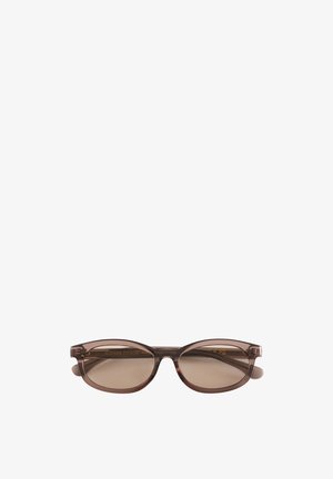 Bruine doorschijnende ovale zonnebril met getinte glazen en smalle pootjes geplaatst tegen een witte achtergrond.